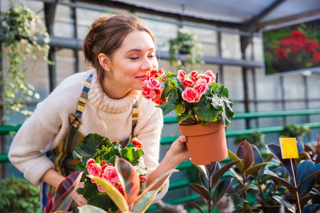 Woman smelling flowers at a greenhouse