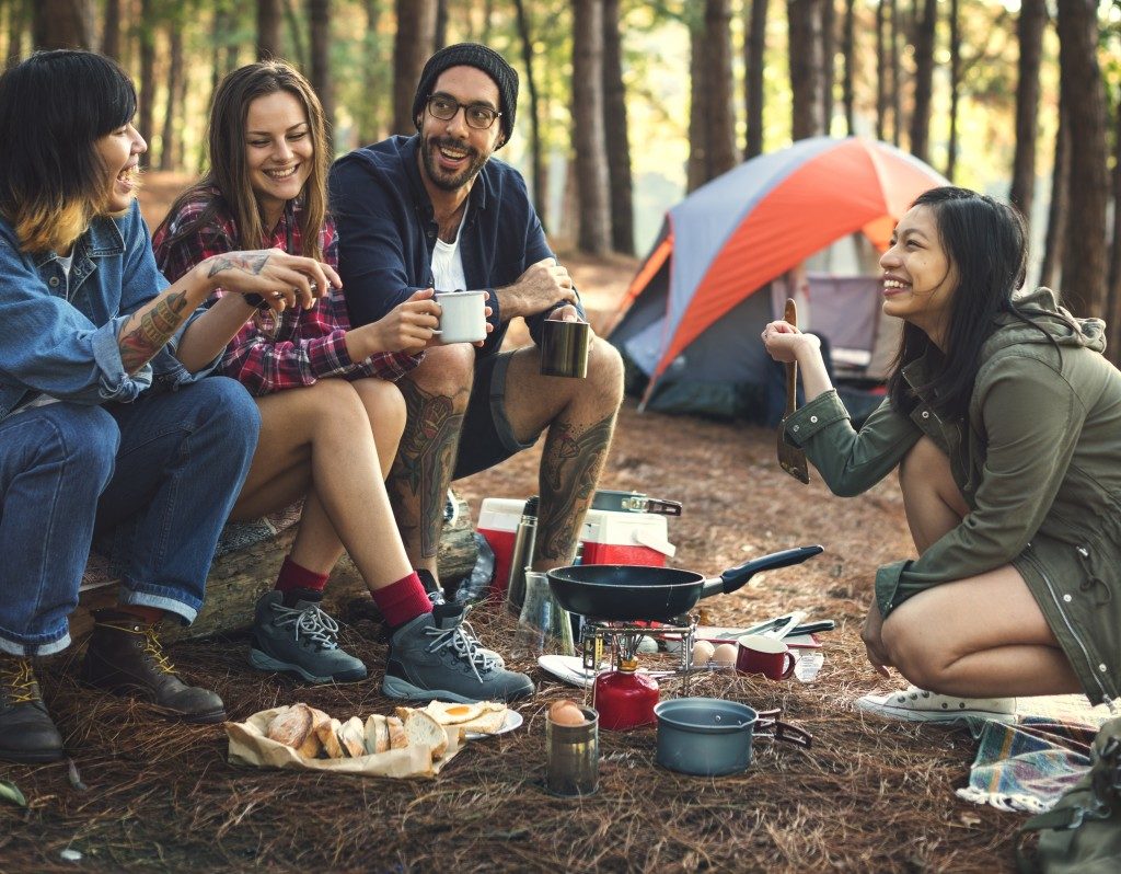 group of friends eating in their camp site